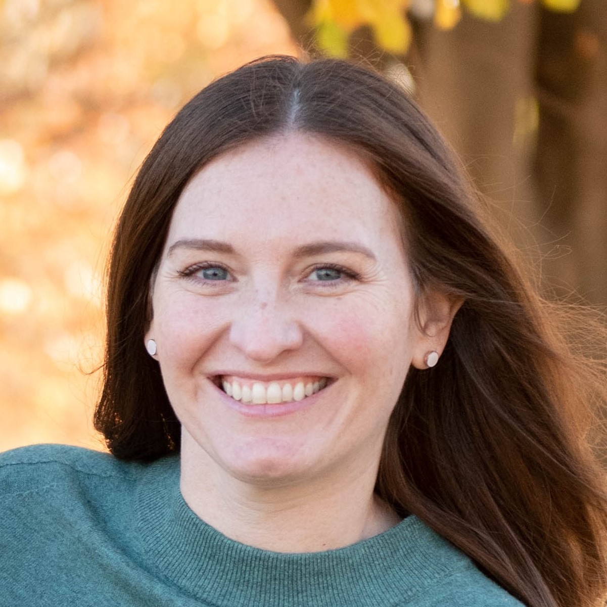 Woman with long brown hair wearing a green top - Natalie Pfenning Manager Certification Program graduate