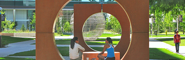 People sitting on sculptures on campus
