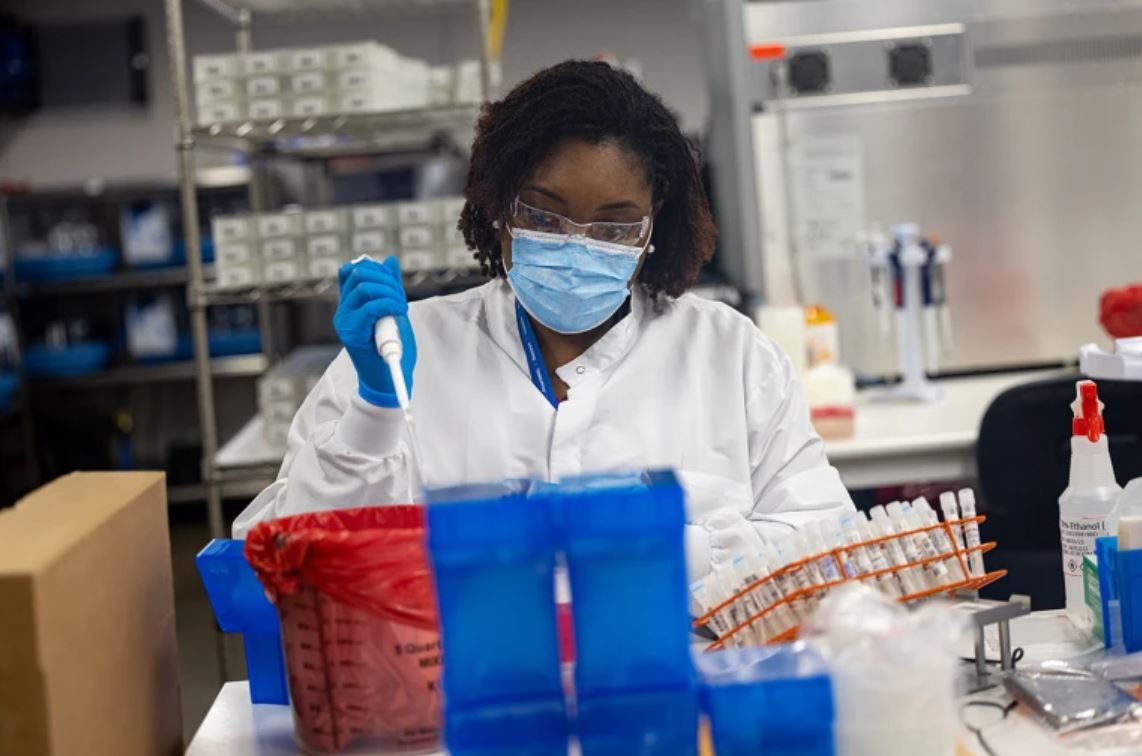 Female in lab with gloves, mask and lab coat