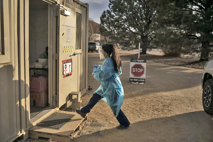 A health-care worker takes a coronavirus test into a mobile lab last month at the Boulder County Fairgrounds in Longmont, Co