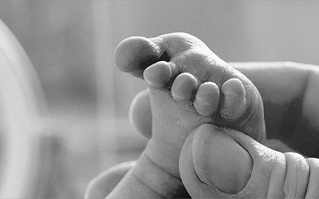 newborn foot and adult hand