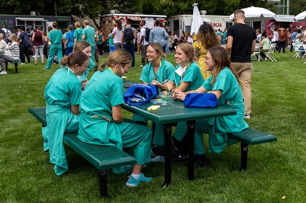 Attendees in scrubs sitting at picnic table.