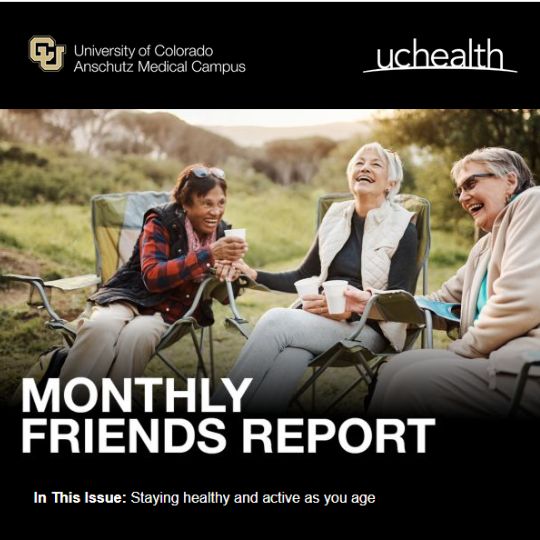 Three senior women are bundled up in the great outdoors, sitting in camping chairs and sharing a laugh.