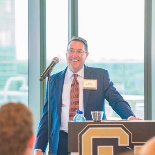 John Messenger, MD, smiling as he stands at a podium giving a speech during the endowed chair celebration.