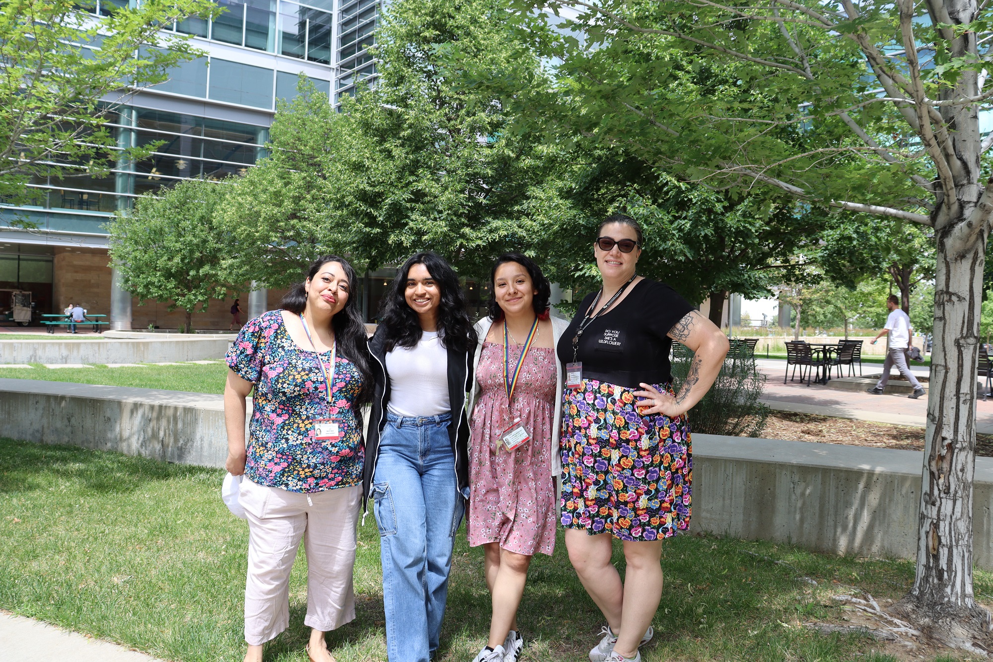 Photo of four CUPS staff members outside, posed together with their arms around one another and smiling.