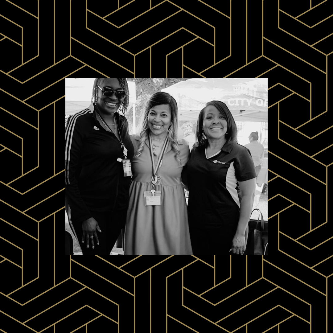 Black and white image of three people smiling with their arms around each others' shoulders over a black and gold geometric pattern