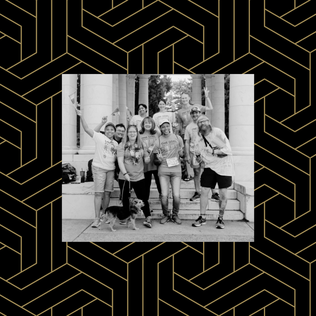 Black and white image of a group of people celebrating Pride Month on campus over a black and gold geometric background.