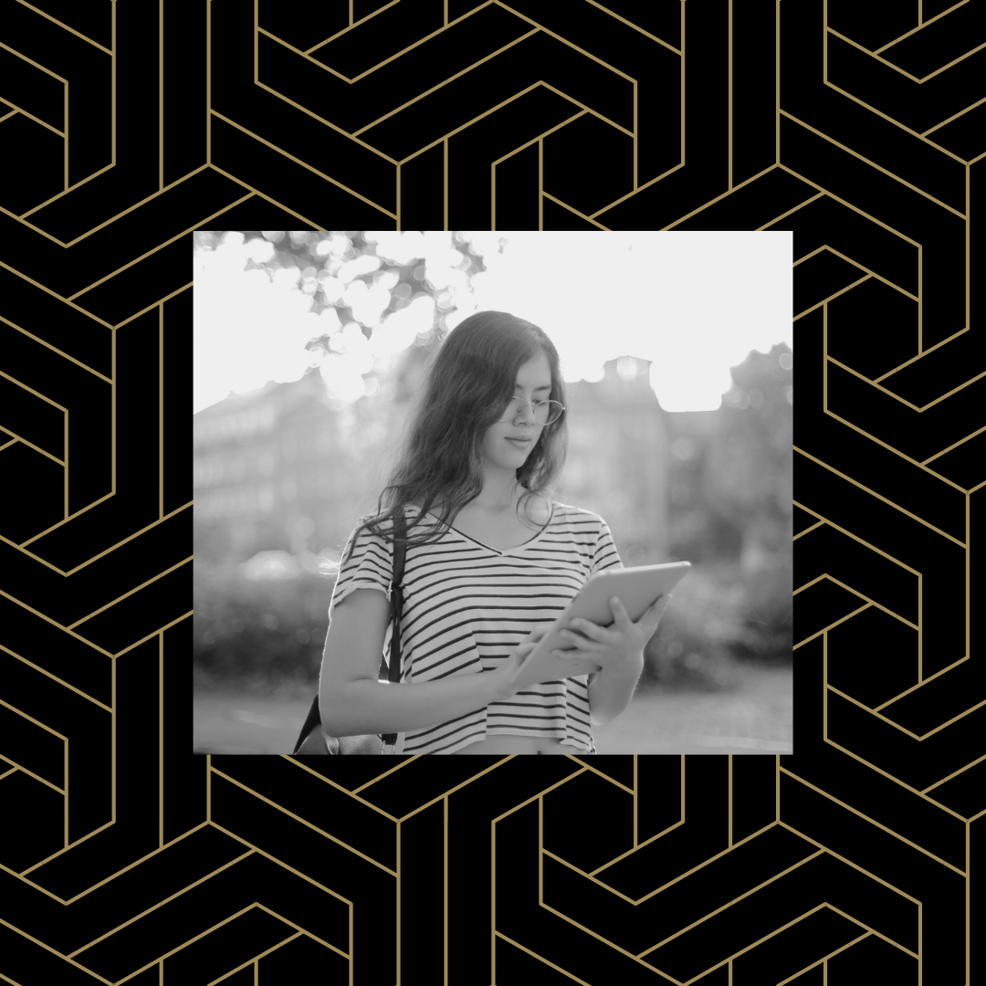 Black and white image of a student in an outdoor setting looking at a tablet over a black and gold geometric background.