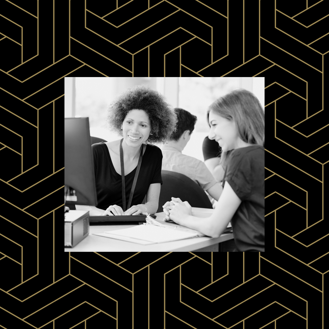 Black and white image of two people working at a computer together over a black and gold geometric pattern