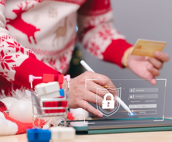 person in a red and white sweater holding a credit card and clicking on an iPad